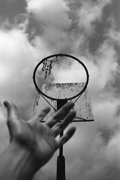 Foto abgeschnittene hand gegen den basketballkorb