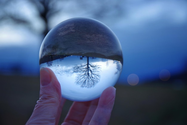 Foto abgeschnittene hand hält eine kristallkugel