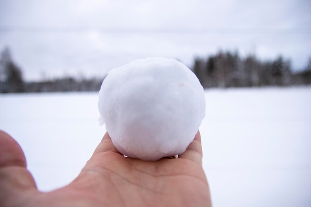 Foto abgeschnittene hand hält einen schneeball