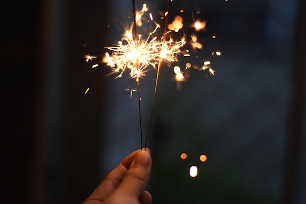 Abgeschnittene Hand hält nachts einen leuchtenden Funken