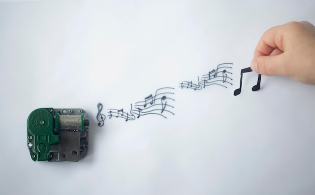 Abgeschnittene Hand mit Musiksymbol mit Audioausrüstung auf weißem Hintergrund
