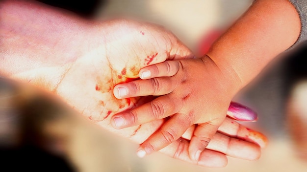 Foto abgeschnittene hand von mutter und baby mit blut zu hause