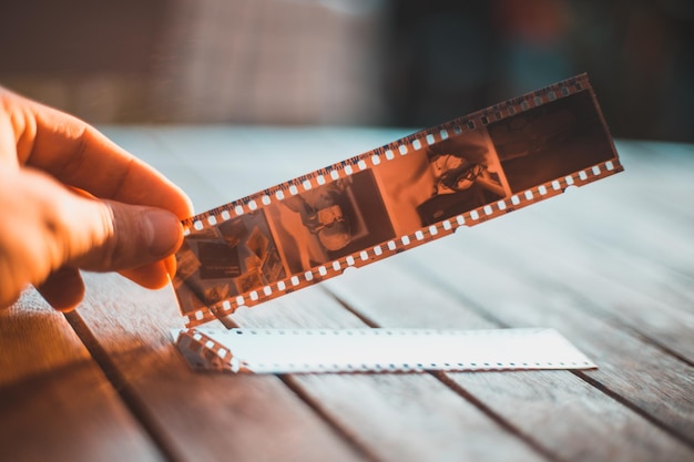 Abgeschnittener Hand, der Kamerafilm auf dem Tisch hält