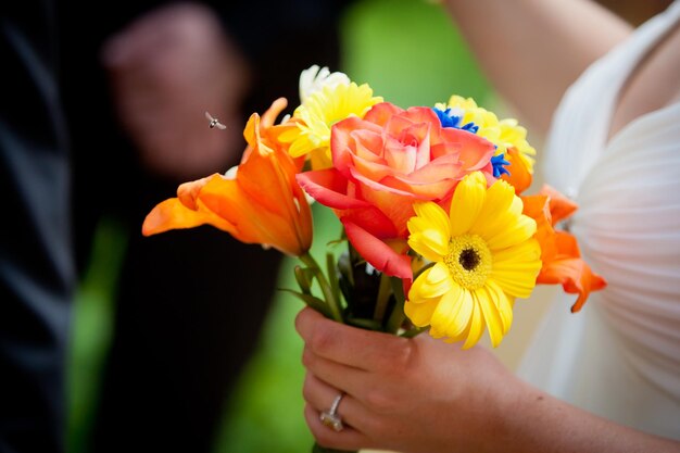 Foto abgeschnittenes bild der braut, die während der hochzeitszeremonie blumen hält