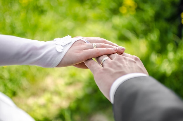 Abgeschnittenes Bild der Hände eines frisch verheirateten Paares
