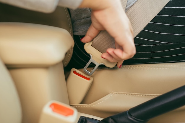 Abgeschnittenes Bild einer Frau, die im Auto sitzt und sich anschnallt