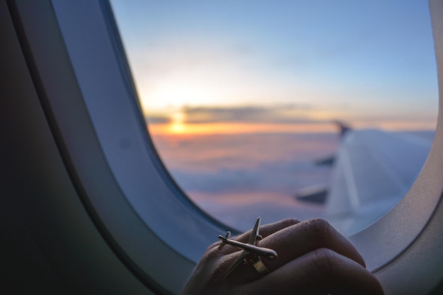 Abgeschnittenes Bild einer Hand an einem Flugzeugfenster