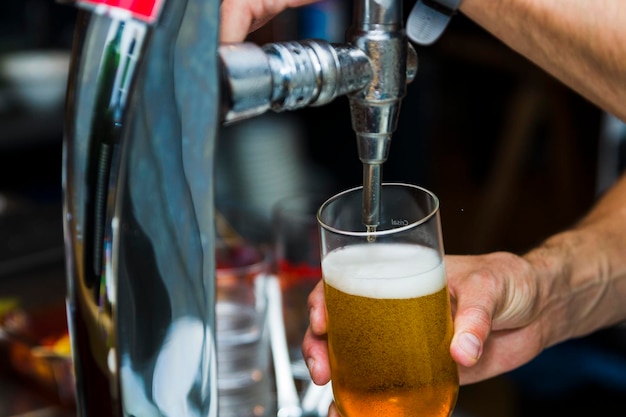 Foto abgeschnittenes bild einer hand, die ein bierglas hält