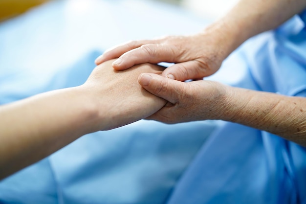 Foto abgeschnittenes bild einer krankenschwester und eines patienten, die sich im krankenhaus die hände halten