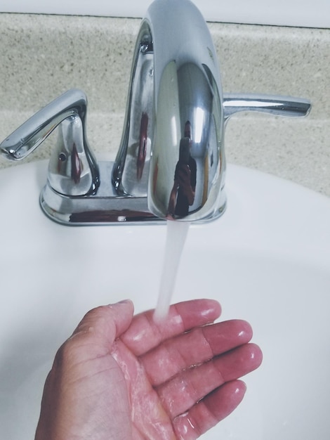 Foto abgeschnittenes bild einer person, die sich die hand im waschbecken wäscht