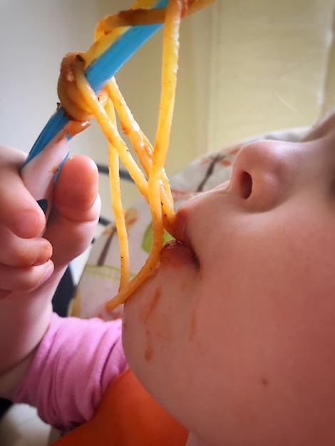 Foto abgeschnittenes bild eines babys, das spaghetti isst
