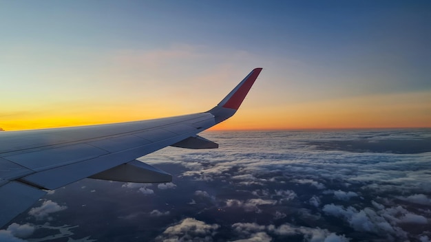 Abgeschnittenes Bild eines Flugzeugflügels gegen den Himmel bei Sonnenuntergang