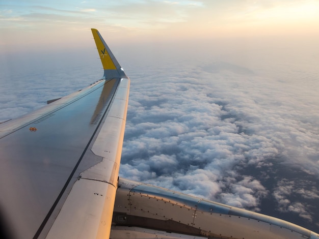 Abgeschnittenes Bild eines Flugzeugflügels gegen den Himmel bei Sonnenuntergang