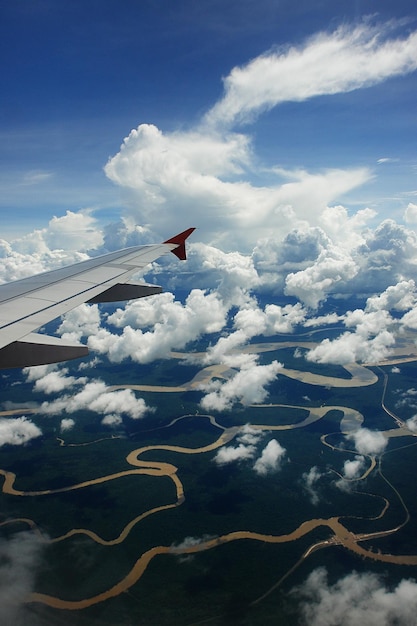 Foto abgeschnittenes bild eines flugzeugs, das über der landschaft gegen den himmel fliegt