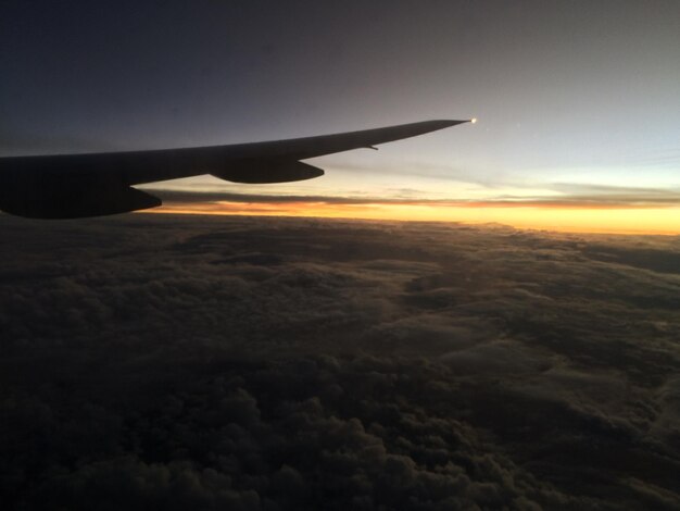 Abgeschnittenes Bild eines Flugzeugs, das über einer Landschaft fliegt