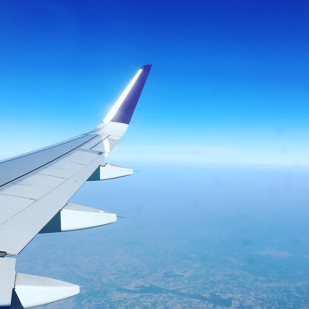Abgeschnittenes Bild eines Flugzeugs vor dem blauen Himmel an einem sonnigen Tag