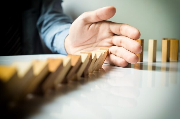 Foto abgeschnittenes bild eines geschäftsmanns, der am schreibtisch im büro domino spielt