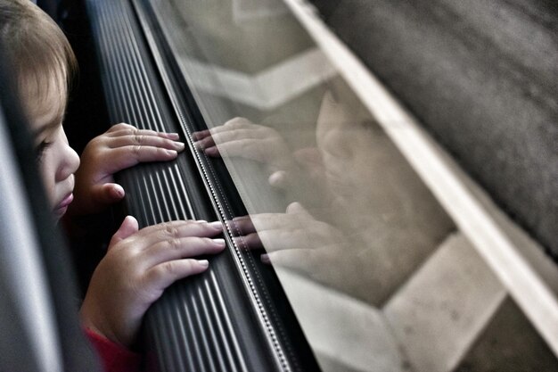 Foto abgeschnittenes bild eines kleinkindes, das durch das autofenster schaut