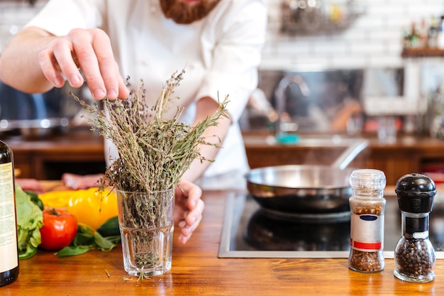 Abgeschnittenes Bild eines Küchenchefs, der Essen in der Küche zubereitet