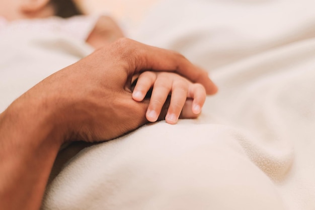 Abgeschnittenes Bild eines Mannes, der zu Hause ein Baby in der Hand hält