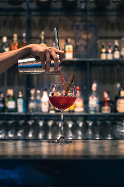 Abgeschnittenes Bild von einem Barkeeper, der an der Theke einen Cocktail zubereitet