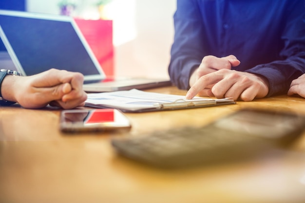 Abgeschnittenes Bild von Geschäftsleuten, die Daten am Tisch im Büro besprechen