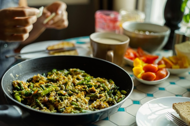 Abgeschnittenes Bild von Händen beim Frühstück, das auf dem Tisch serviert wird