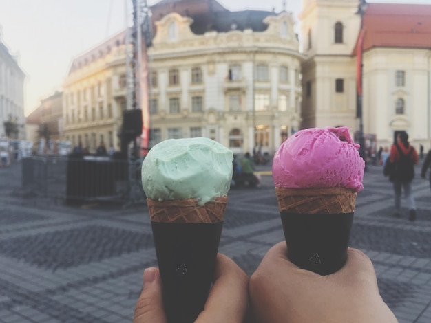 Foto abgeschnittenes bild von händen, die eis in der stadt halten