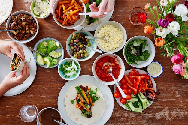 Abgeschnittenes Bild von Händen, die Essen am Tisch haben