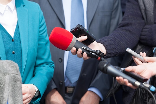 Abgeschnittenes Bild von Journalisten, die die Antwort des Geschäftsmanns aufnehmen