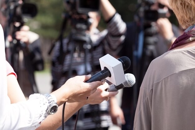 Abgeschnittenes Bild von Journalisten, die eine Frau interviewen