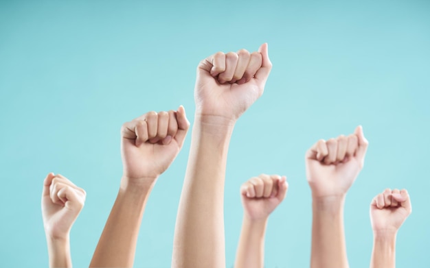 Abgeschnittenes Bild von Menschen mit erhobener Hand auf blauem Hintergrund