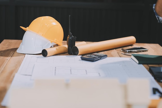Abgeschnittenes Foto von zwei jungen Architekten, die zusammen auf einer Baustelle arbeiten