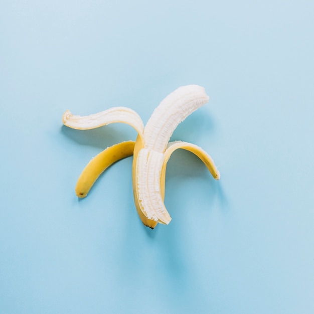 Abgezogene Banane auf blauem Hintergrund