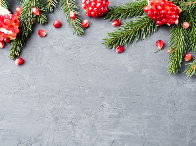 Abgezogener saftiger roter Granat in einer Weinleseplatte auf Weihnachtsbaum