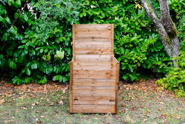 Abierta de madera en el contenedor de compostaje del jardín con material orgánico