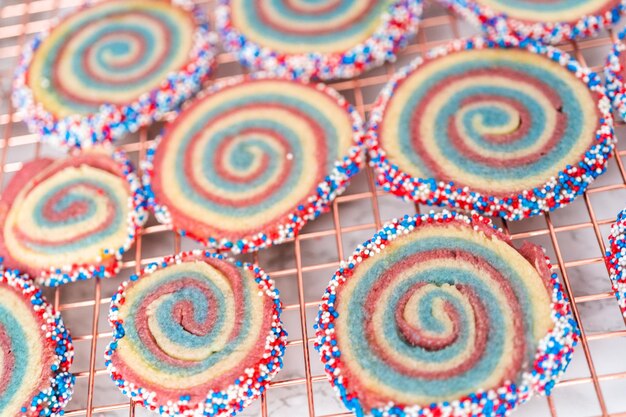 Abkühlen von roten, weißen und blauen Pinwheel-Zuckerplätzchen auf einem Kühlregal. Dessert für die Feier am 4. Juli.