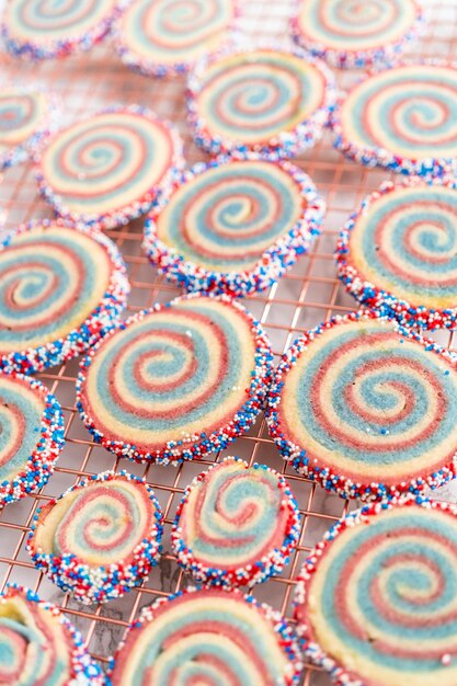 Abkühlen von roten, weißen und blauen Pinwheel-Zuckerplätzchen auf einem Kühlregal. Dessert für die Feier am 4. Juli.