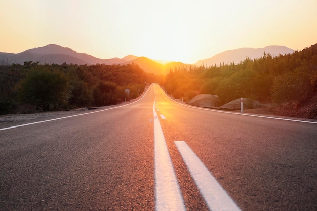 Abnehmende Perspektive der Straße inmitten der Berge gegen den Himmel während des Sonnenuntergangs