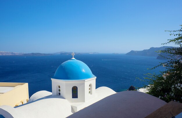 Abóbada azul da igreja e da água do mar azul em Santorini.