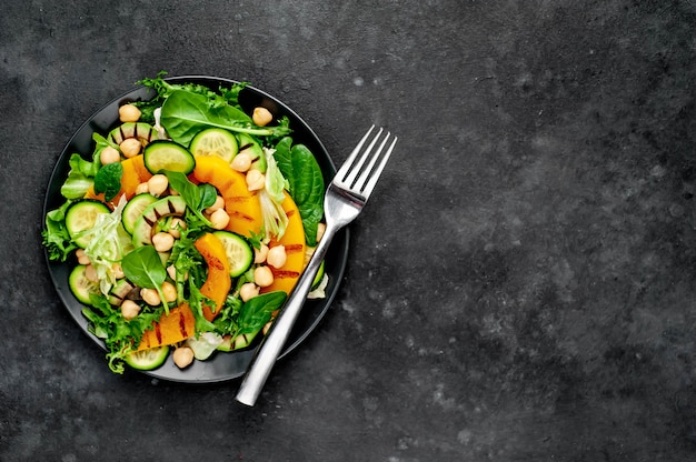 abóbora, abacate, pepino, grão de bico, salada em um prato. Salada saudável saborosa