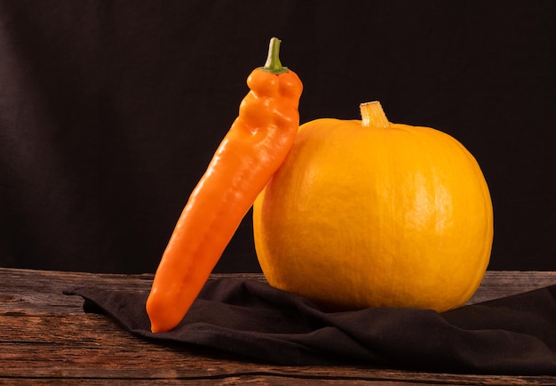 Abóbora amarela e pimenta longa em um espaço de mesa velha de madeira para texto