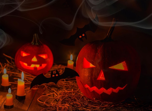 Abóbora de Halloween com velas e morcegos em fundo preto. Grande símbolo de halloween assustador