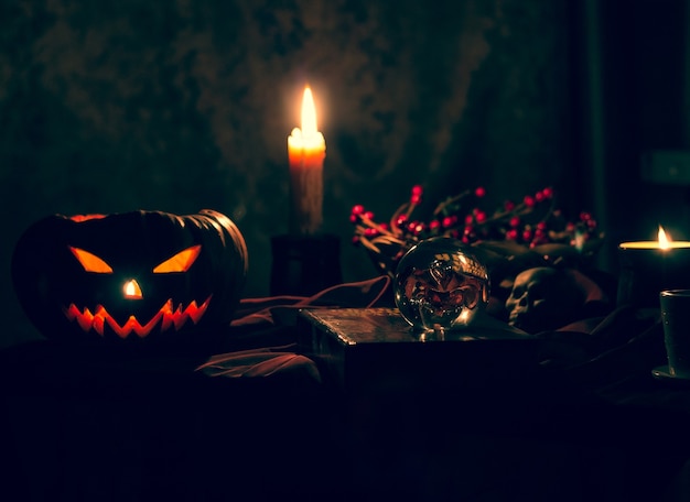 Abóbora de Halloween em um fundo preto místico. Velas acesas, um símbolo das férias de outono.