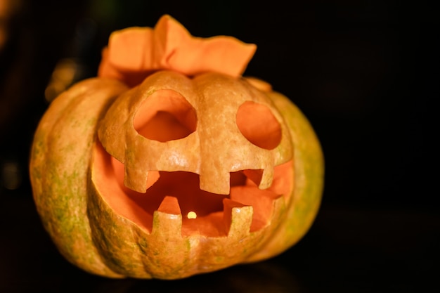 Foto abóbora de halloween laranja com cara engraçada sobre o fundo escuro