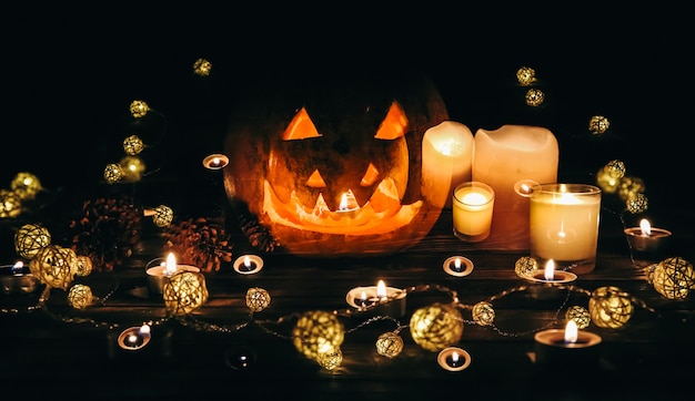 Abóbora de Halloween na escuridão. Acende lâmpadas e velas. Férias místicas de outono. Detalhes festivos. Tradição doçura ou travessura. Dia de Todos os Santos em outubro.