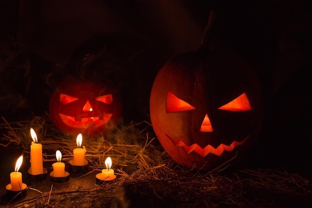 Foto abóbora de helloween com velas em fundo preto. grande símbolo de halloween assustador