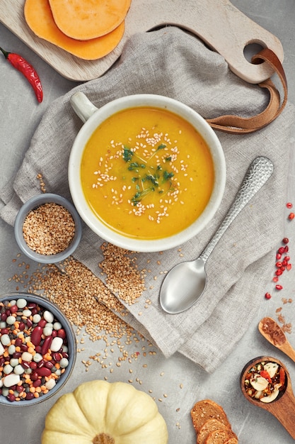 Abóbora, feijão misto e sopa de creme de batata doce em uma tigela de cerâmica, vista superior com ingredientes