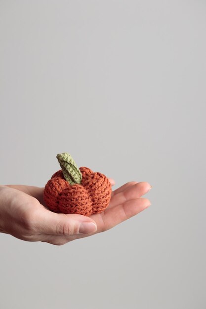 Abóbora laranja de malha de crochê bonito no fundo branco