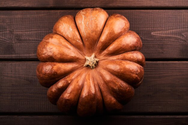 Abóbora laranja madura inteira perto do fundo de madeira